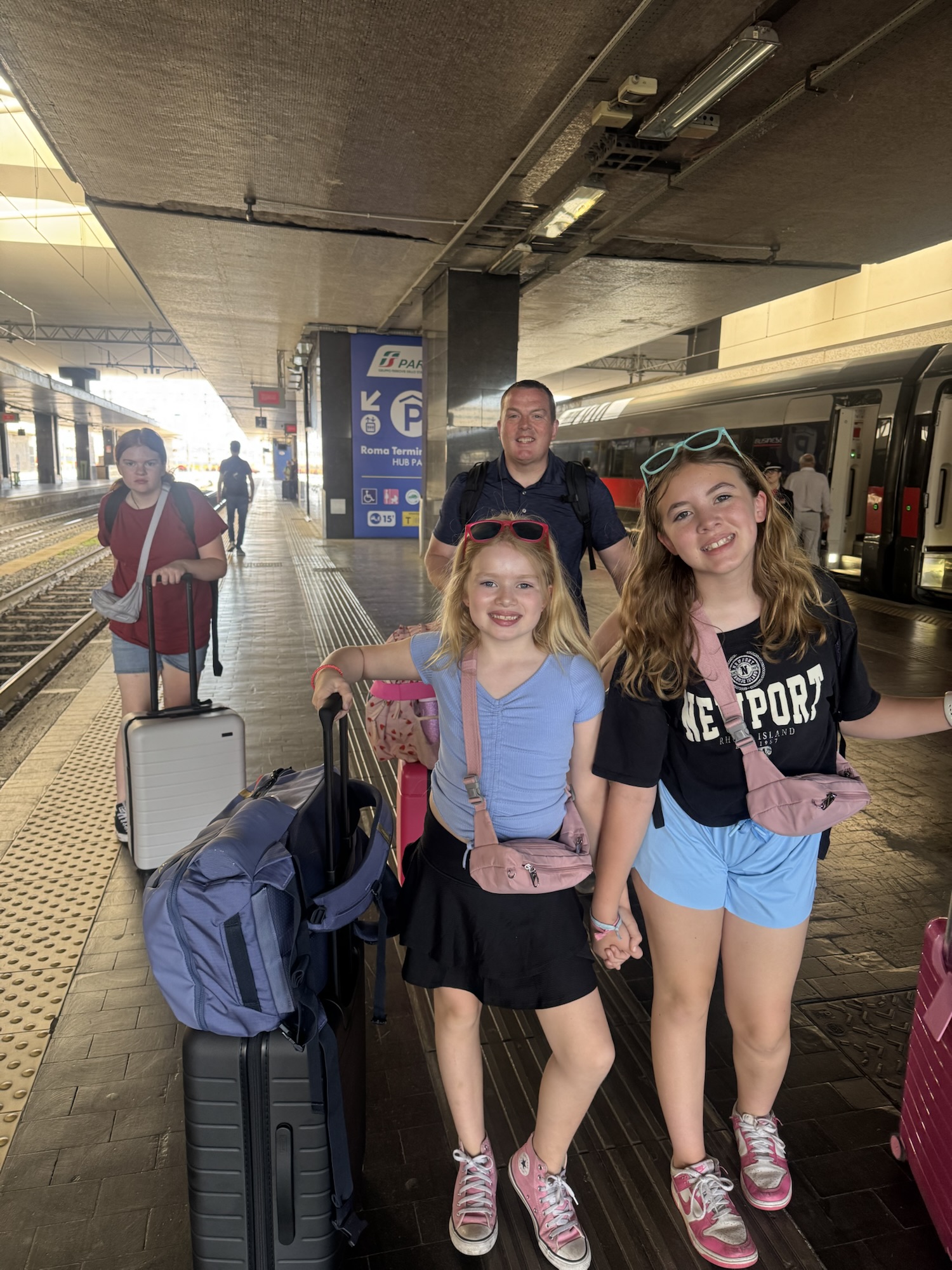 Dad and daughter at train station with luggage
