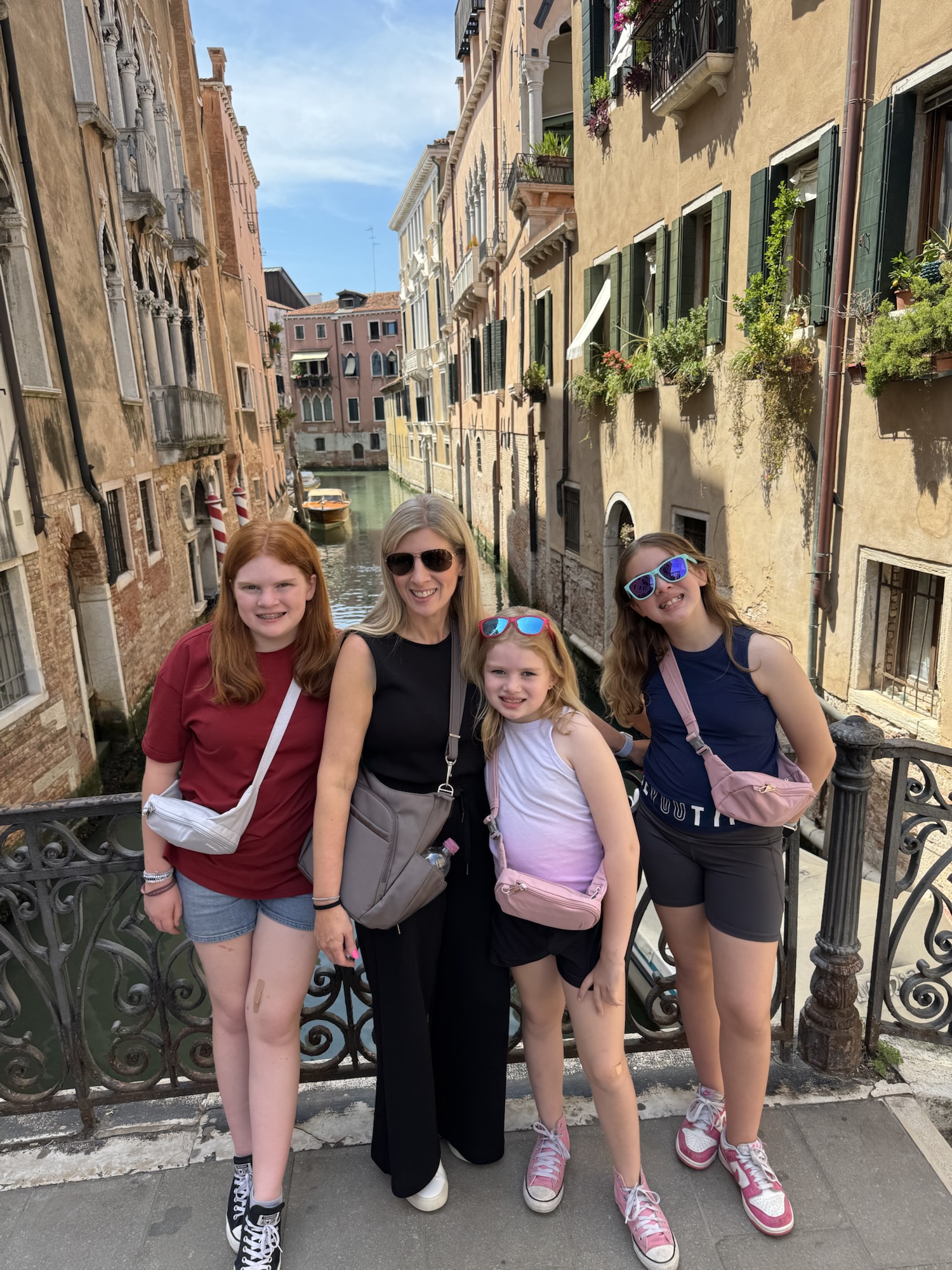 Four girls with travel bags in Venice